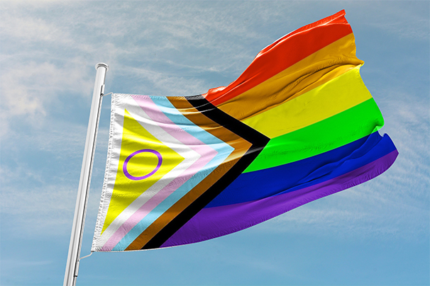 Intersex progress pride flag flying against a sunny blue sky background.