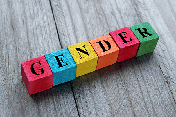 A set of wooden letter blocks in different colours arranged to spell the word gender.